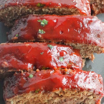 A close image of chopped parsley sprinkled over ketchup-glazed meatlaof.