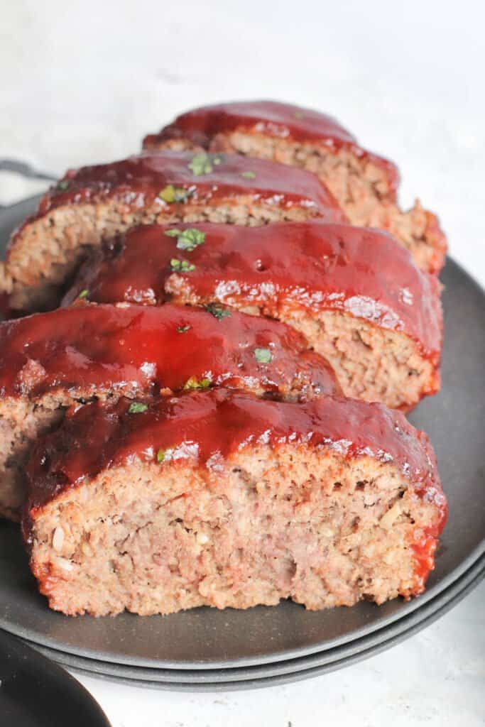 Sliced meatloaf made in the air fryer on a black plate.