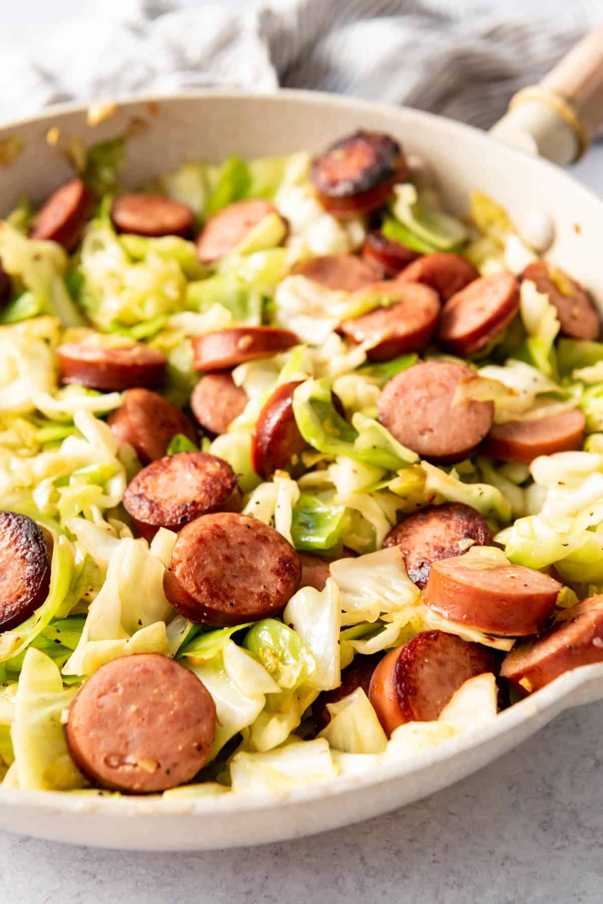 A skillet cabbage and sausage meal in a large pan.