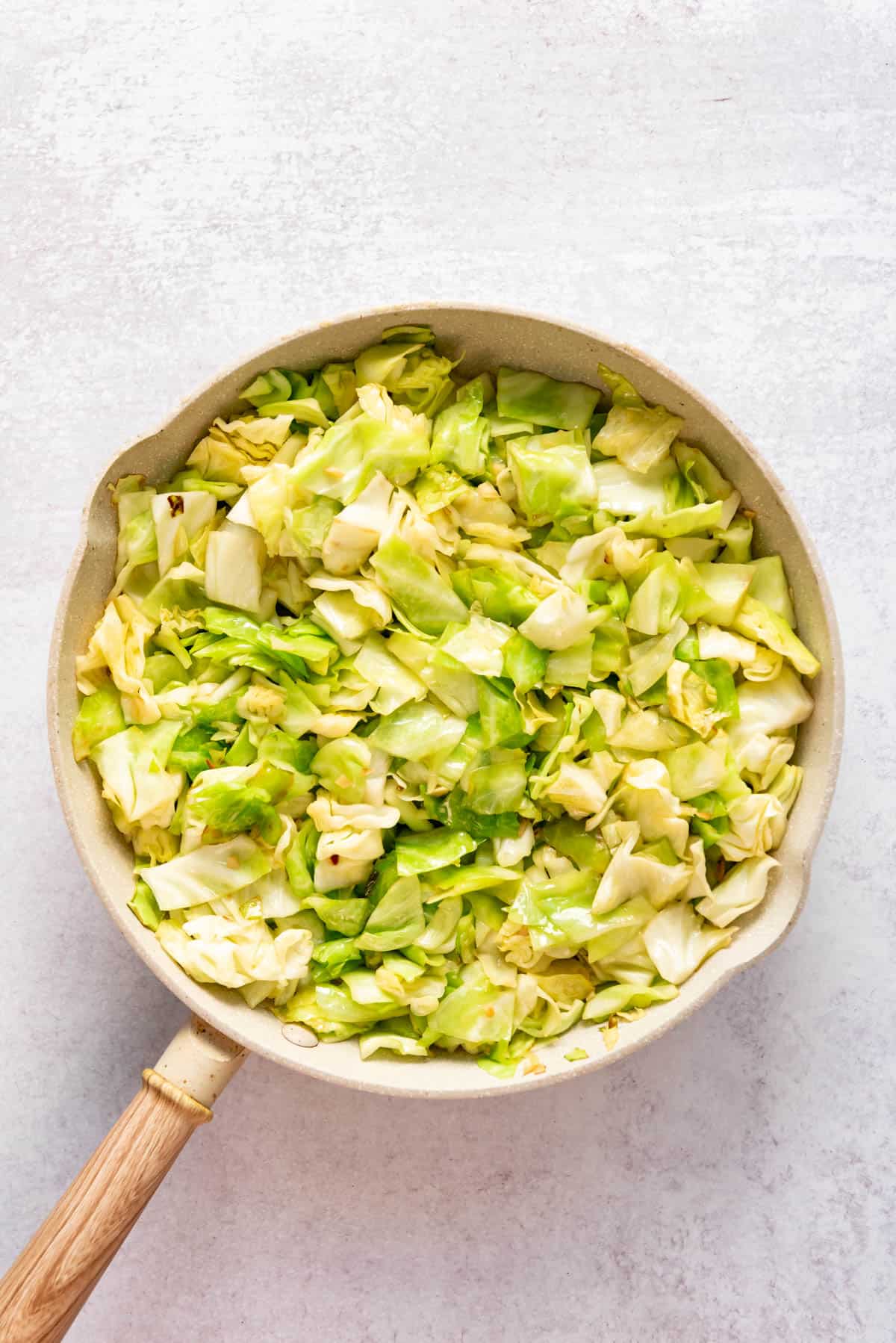 Wilted, chopped green cabbage in a pan after being sauteed.
