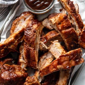 A pile of sliced Instant Pot baby back ribs with barbecue sauce.