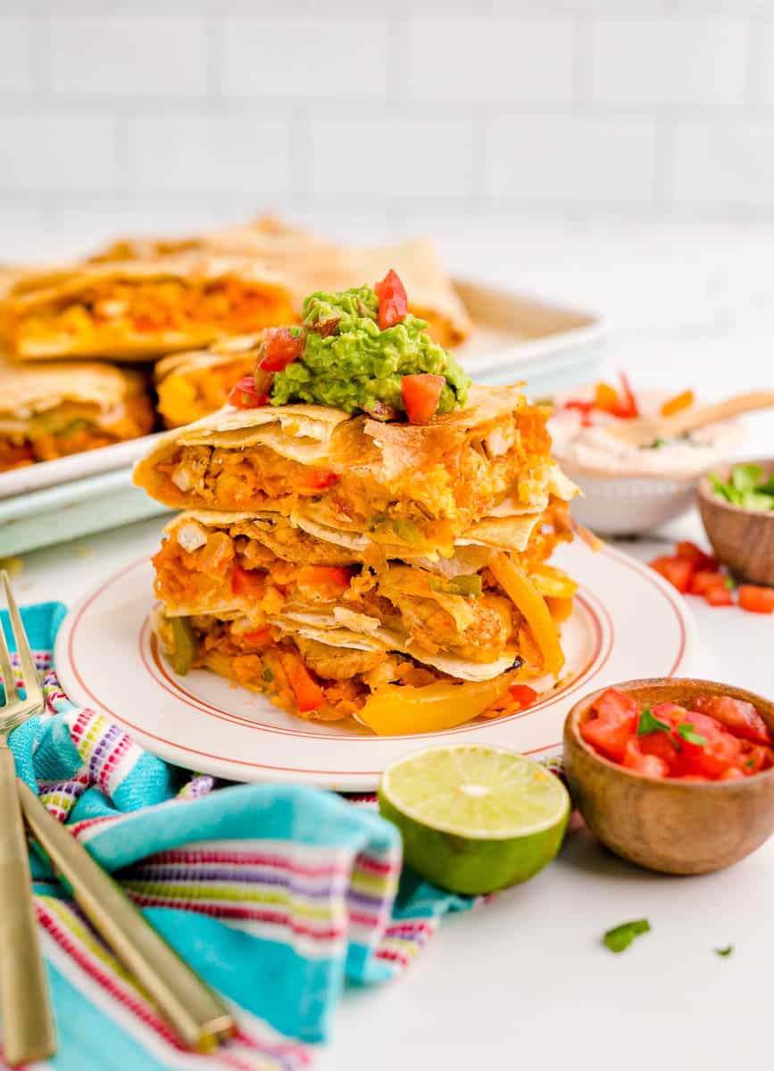 A stack of chicken sheet pan quesadillas on a plate.