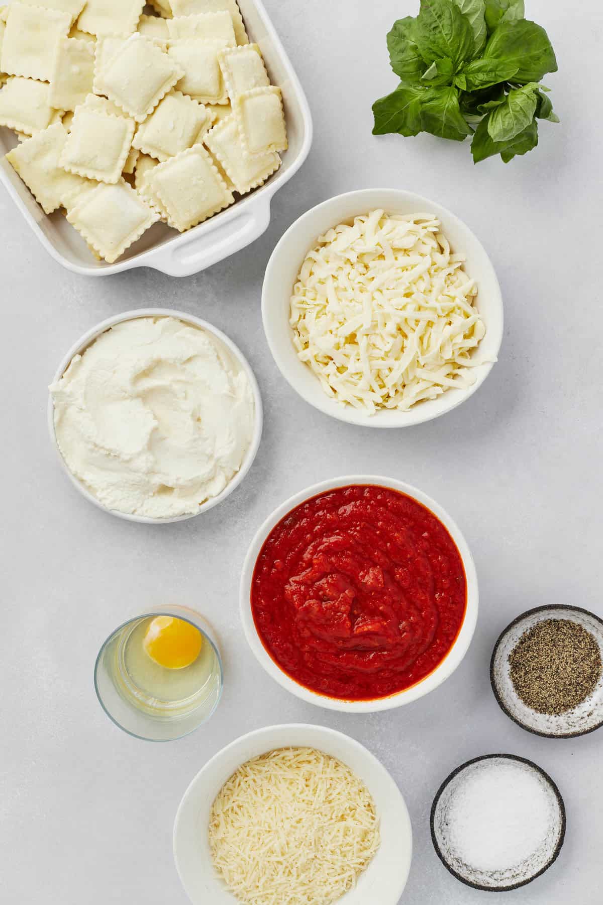 Ingredients for ravioli lasagna in separate bowls.