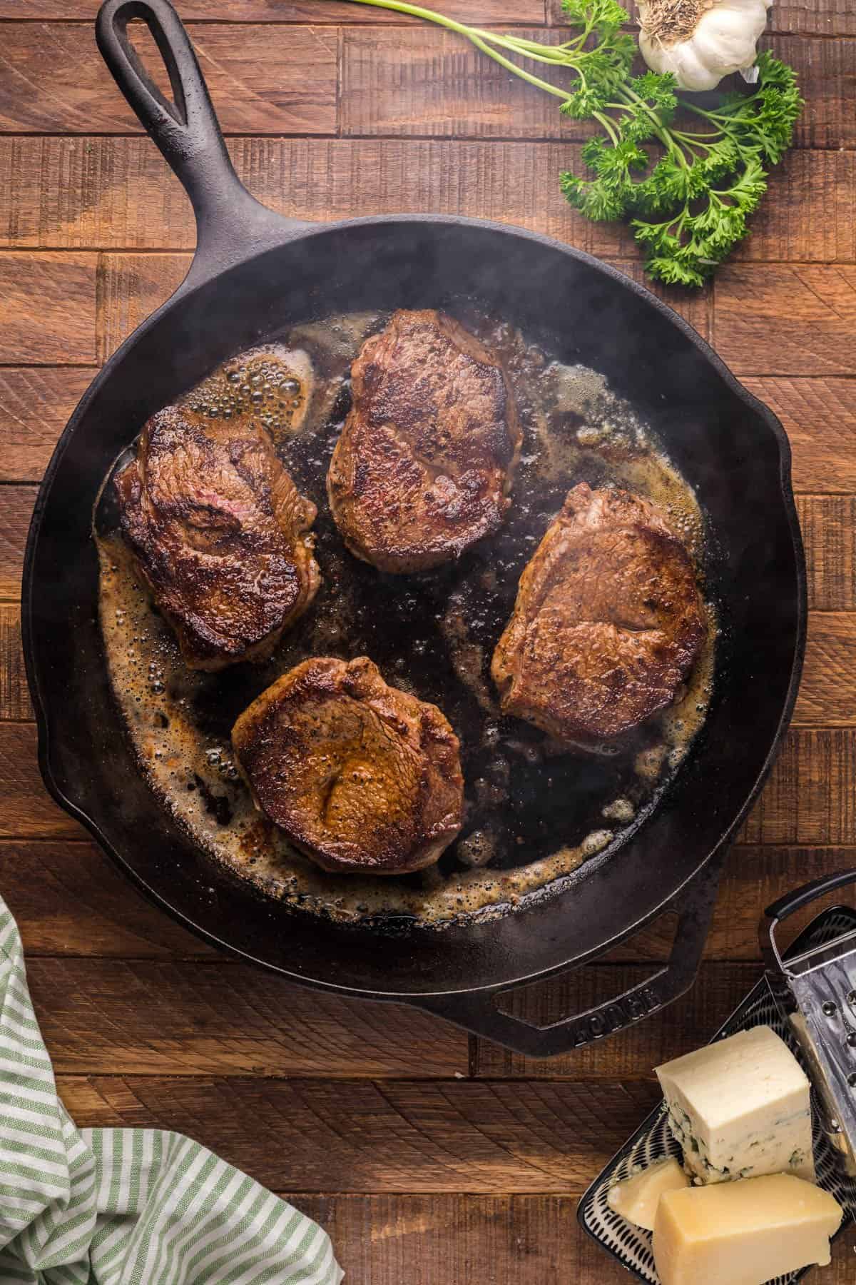 Searing steak in a cast iron skillet.