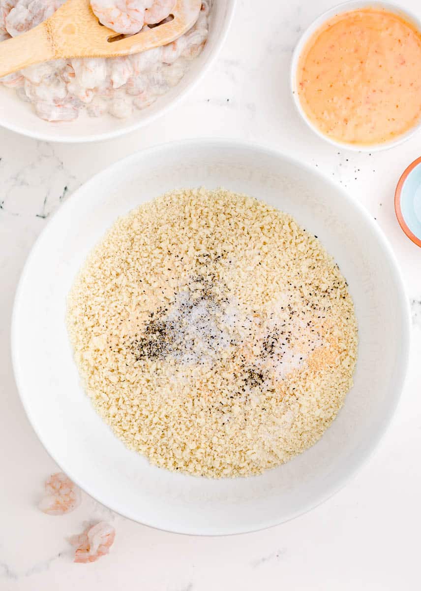 Panko breadcrumbs in a large mixing bowl with salt, pepper, onion powder and garlic powder