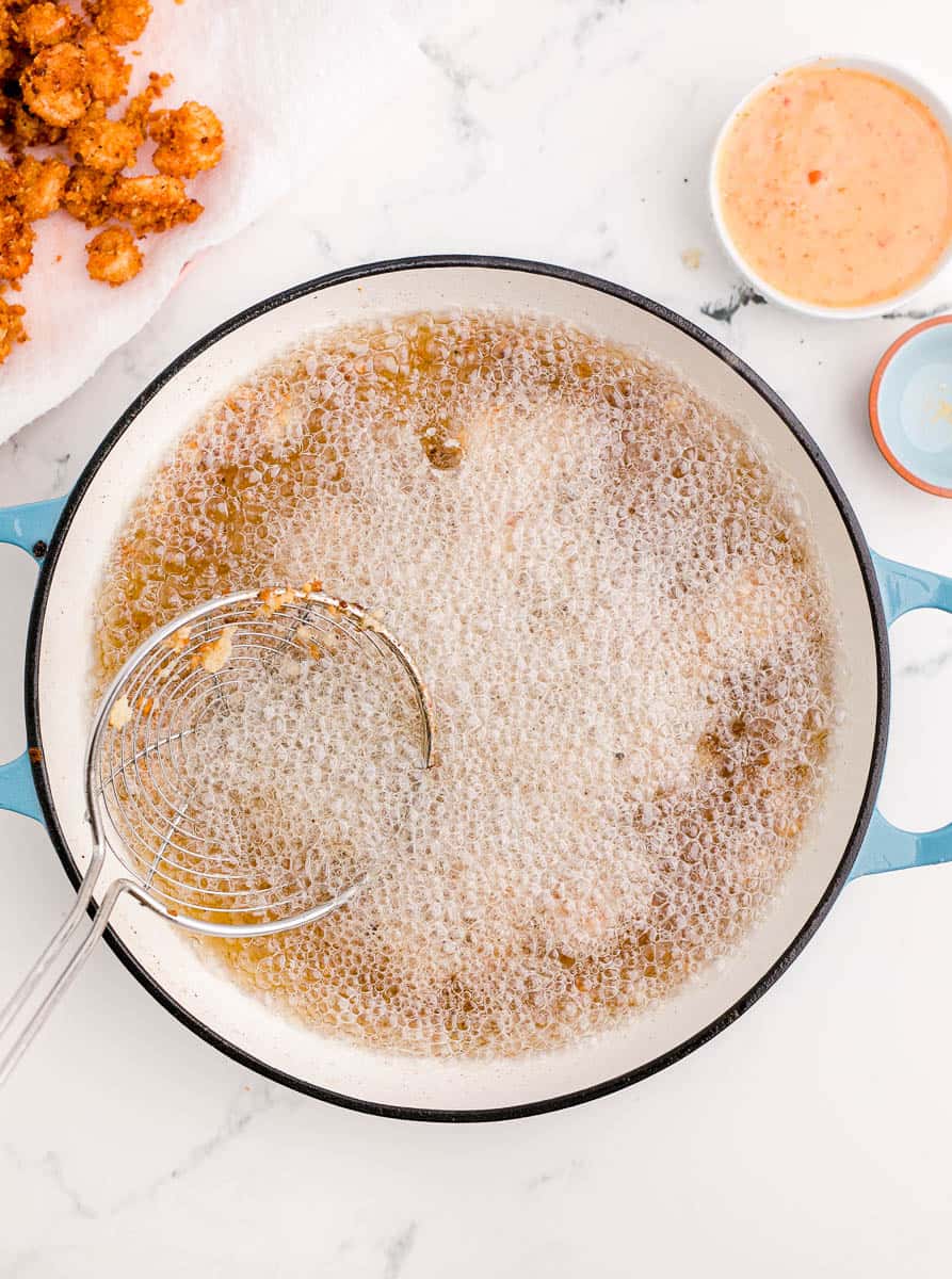 Breaded shrimp cooking in a pot of oil