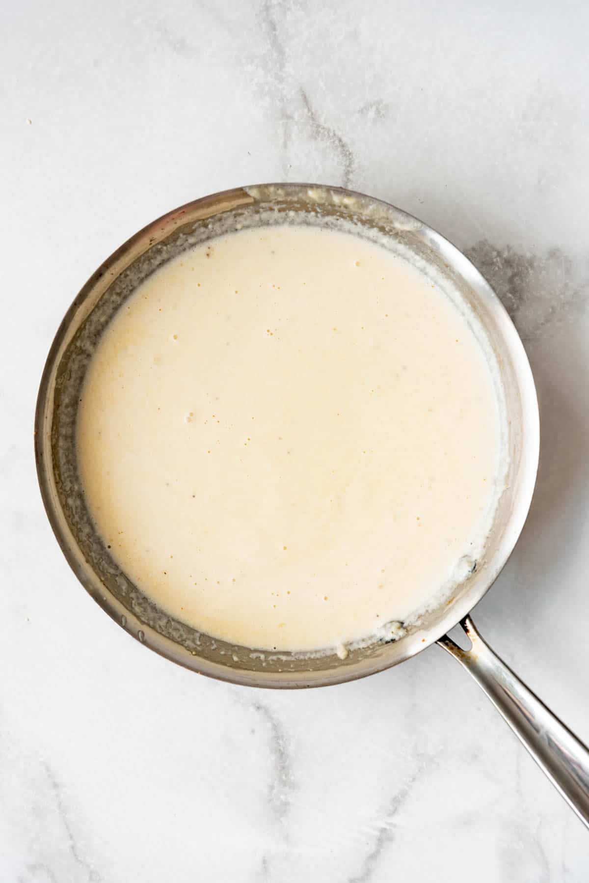 Homemade alfredo sauce in a pan.