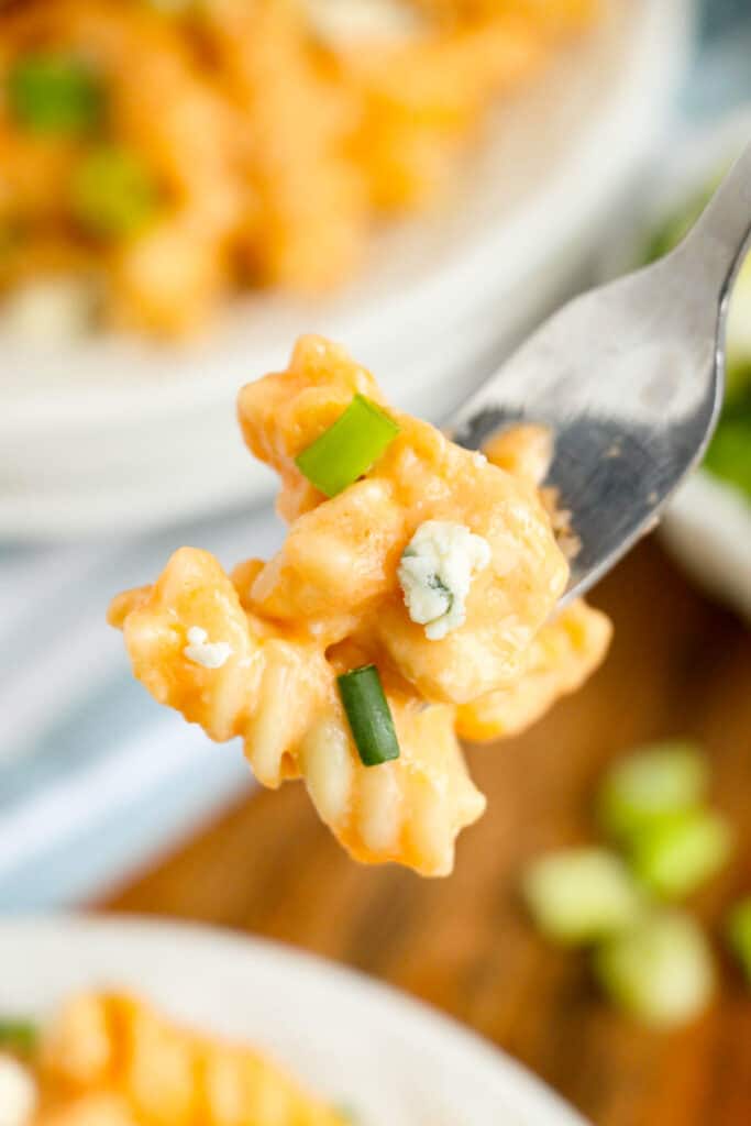 A fork holding a bite of Instant Pot buffalo chicken pasta.