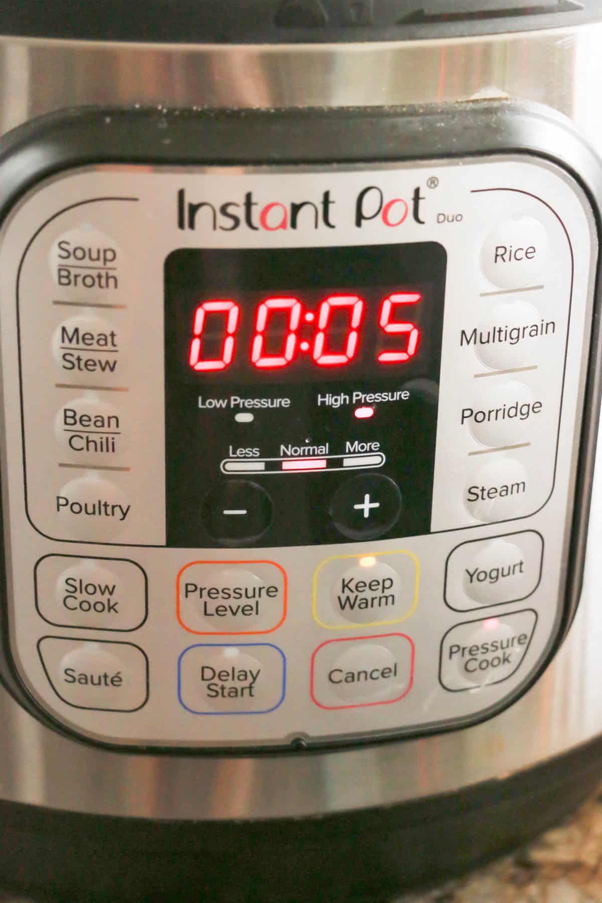 An instant pot with five minutes set on the high pressure setting.