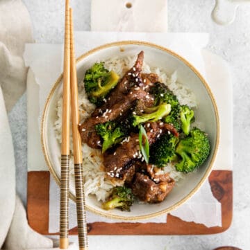 A bowl of instant pot mongolian beef with chopsticks.