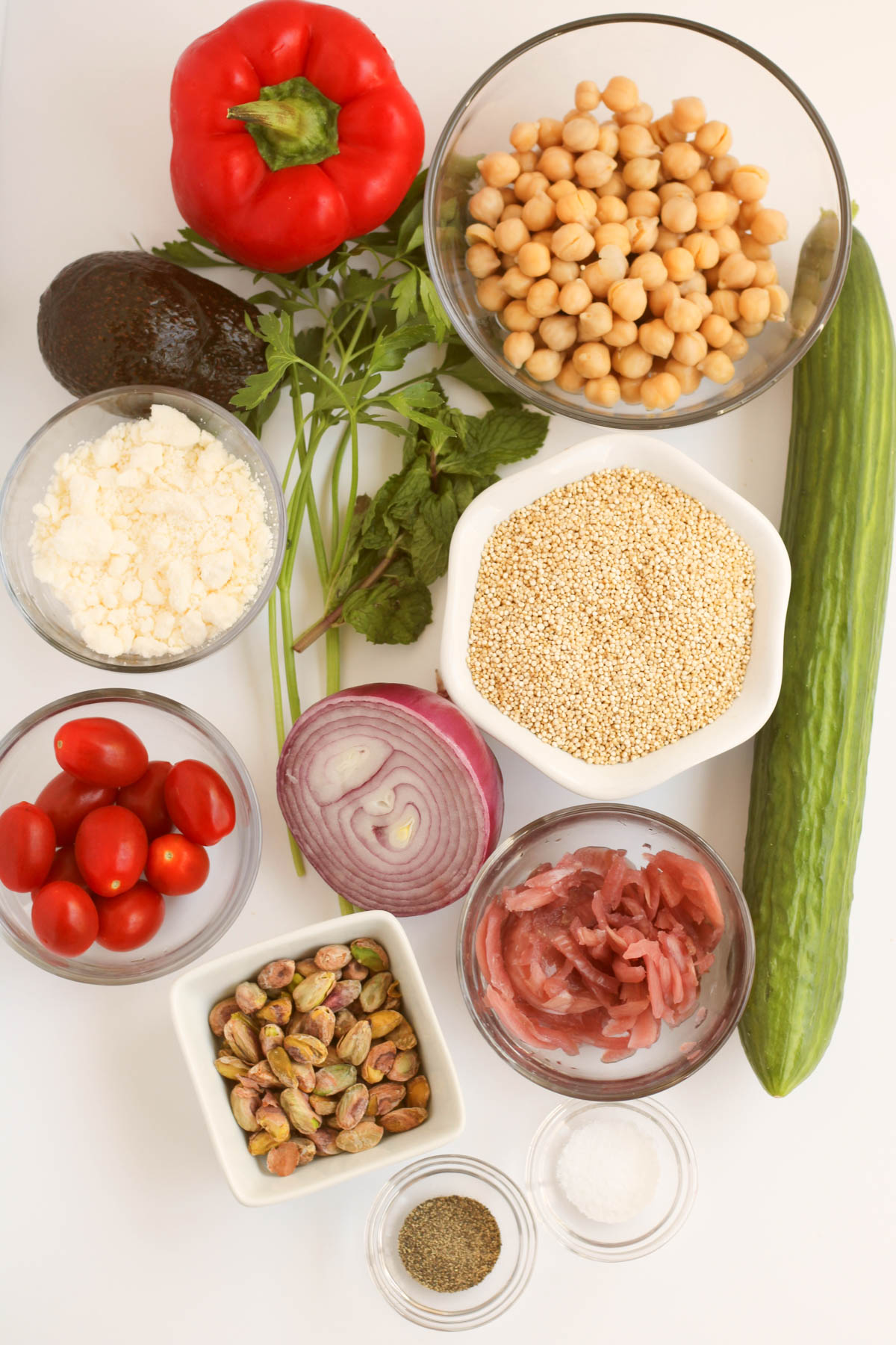 Vegetables, chickpeas and quinoa are displayed in individual bowls. 