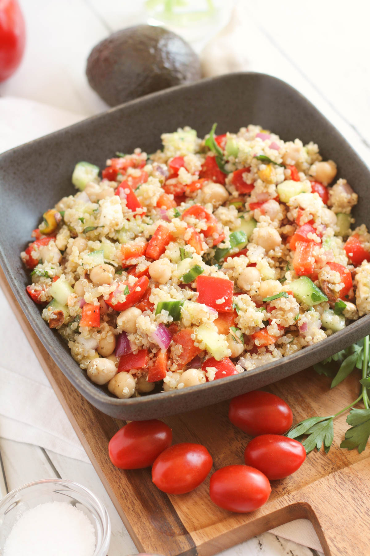 Image of a quinoa and vegetable salad with ingredients placed around the serving bowl. 