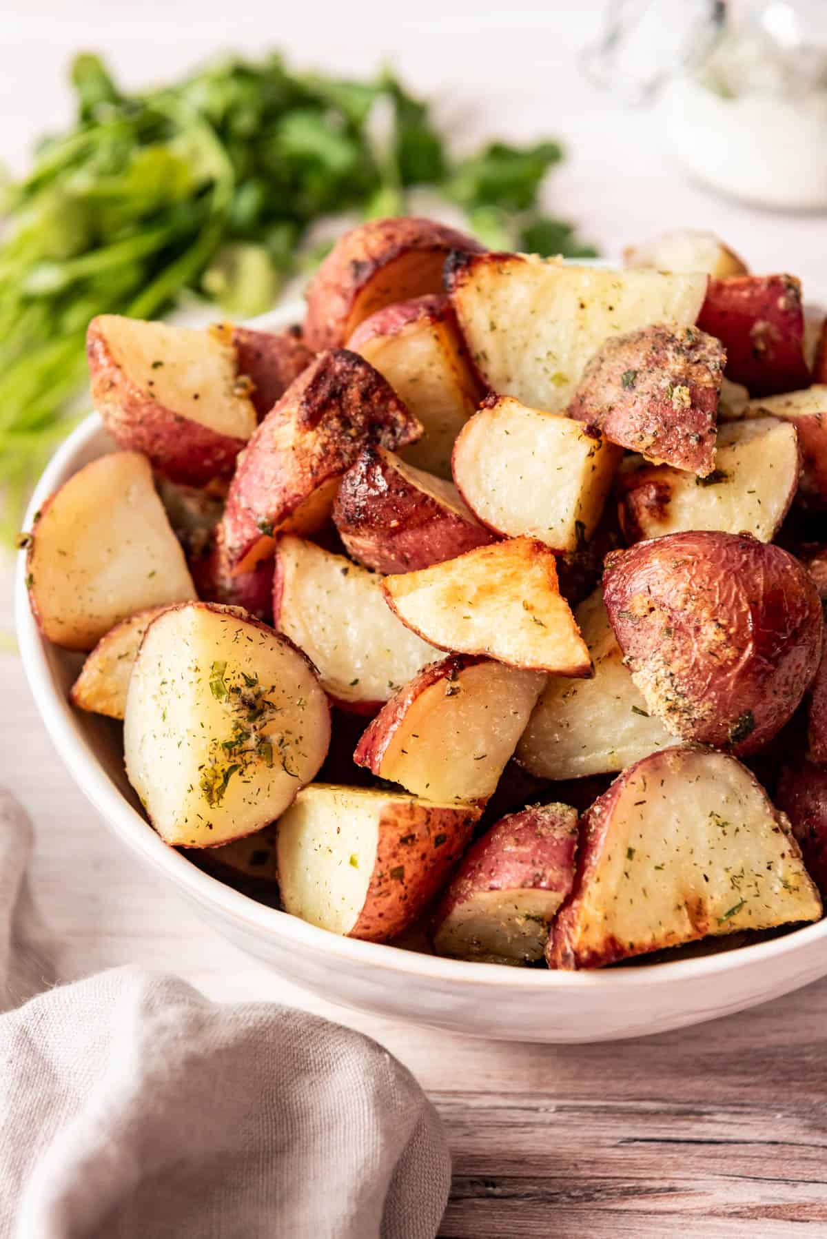 Roasted red potatoes with ranch seasoning in a white bowl.