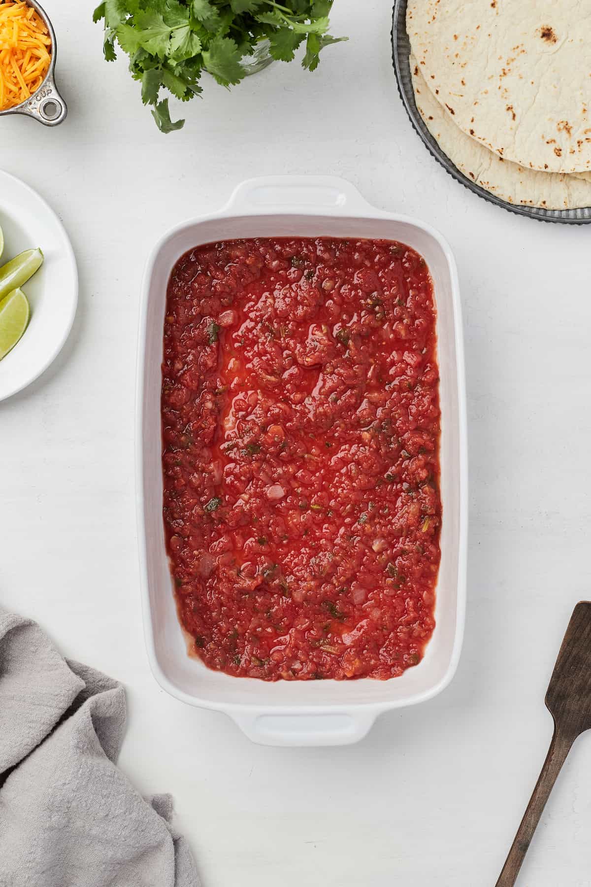 Chunky red salsa spread evenly into the bottom of a 9x13-inch baking dish