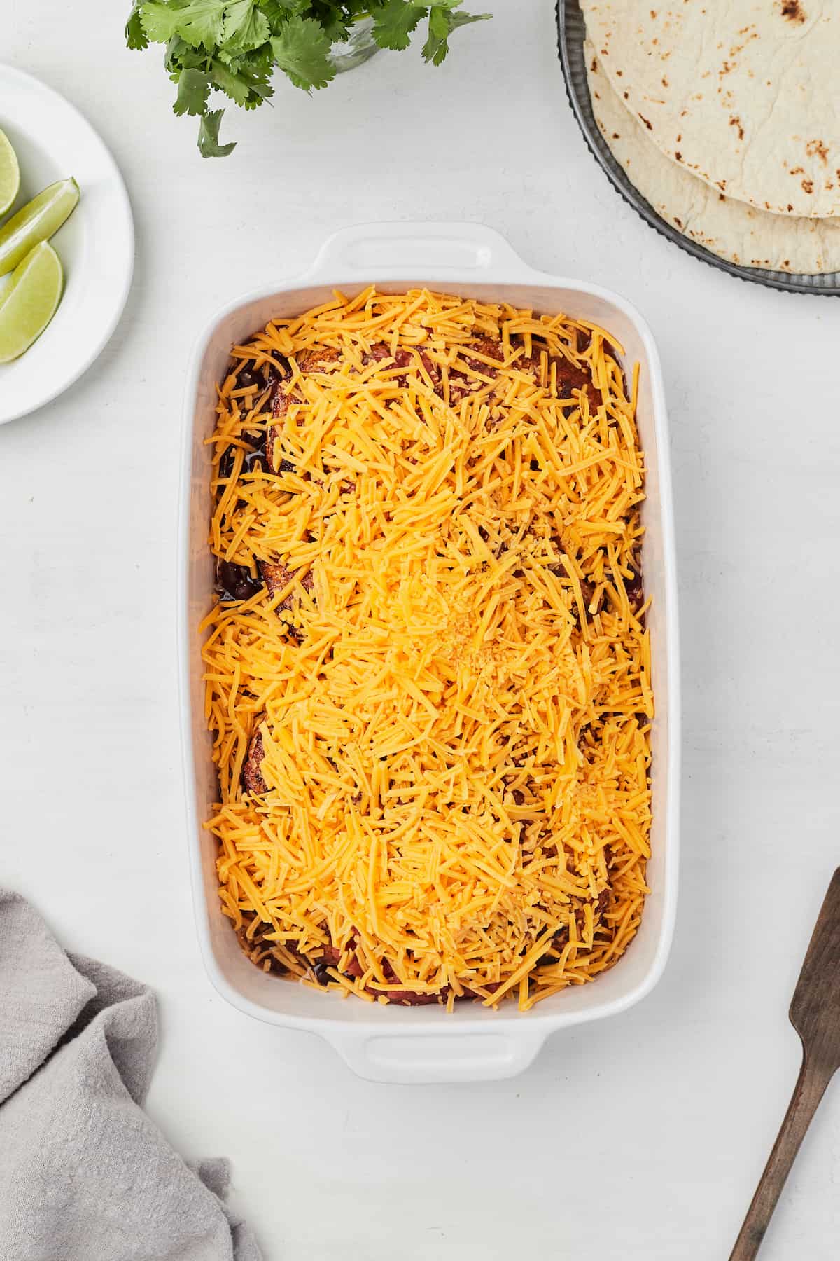 Salsa, black beans, chicken and shredded cheddar cheese inside of a large casserole dish