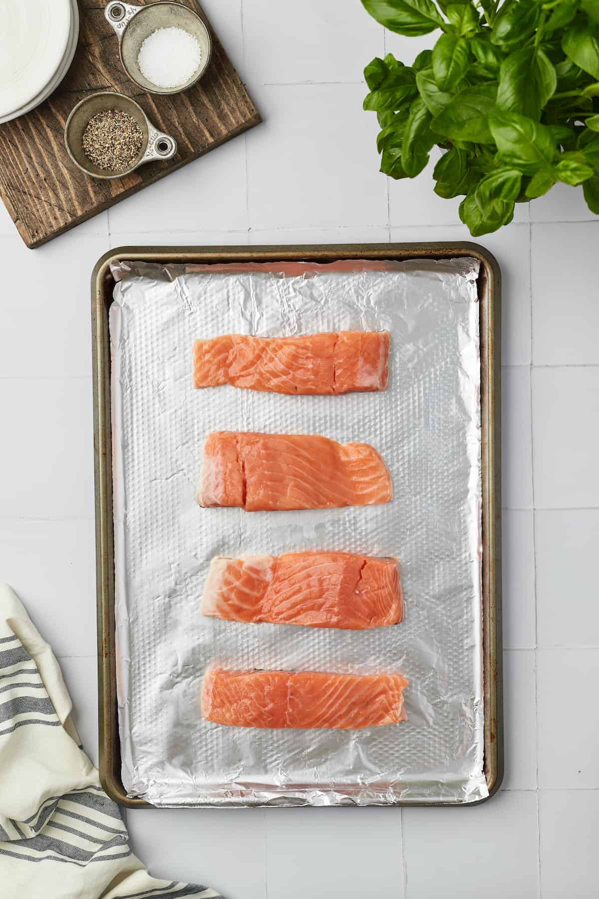 Overhead view of uncooked salmon fillets on sheet pan