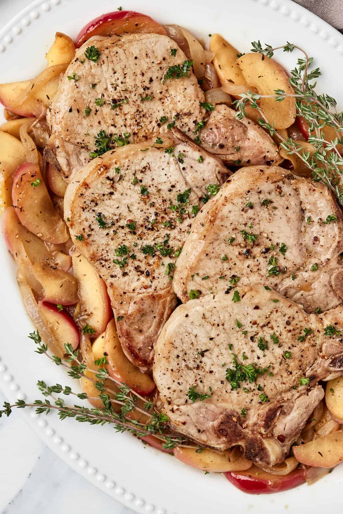 Pork chops with apples and onions on serving platter