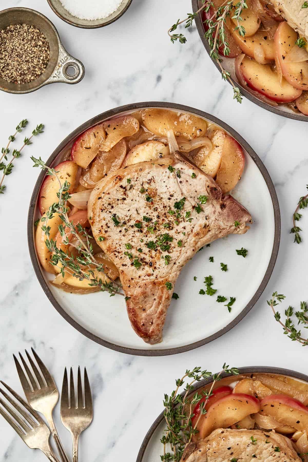 Overhead view of pork chops with apples and onions on plate