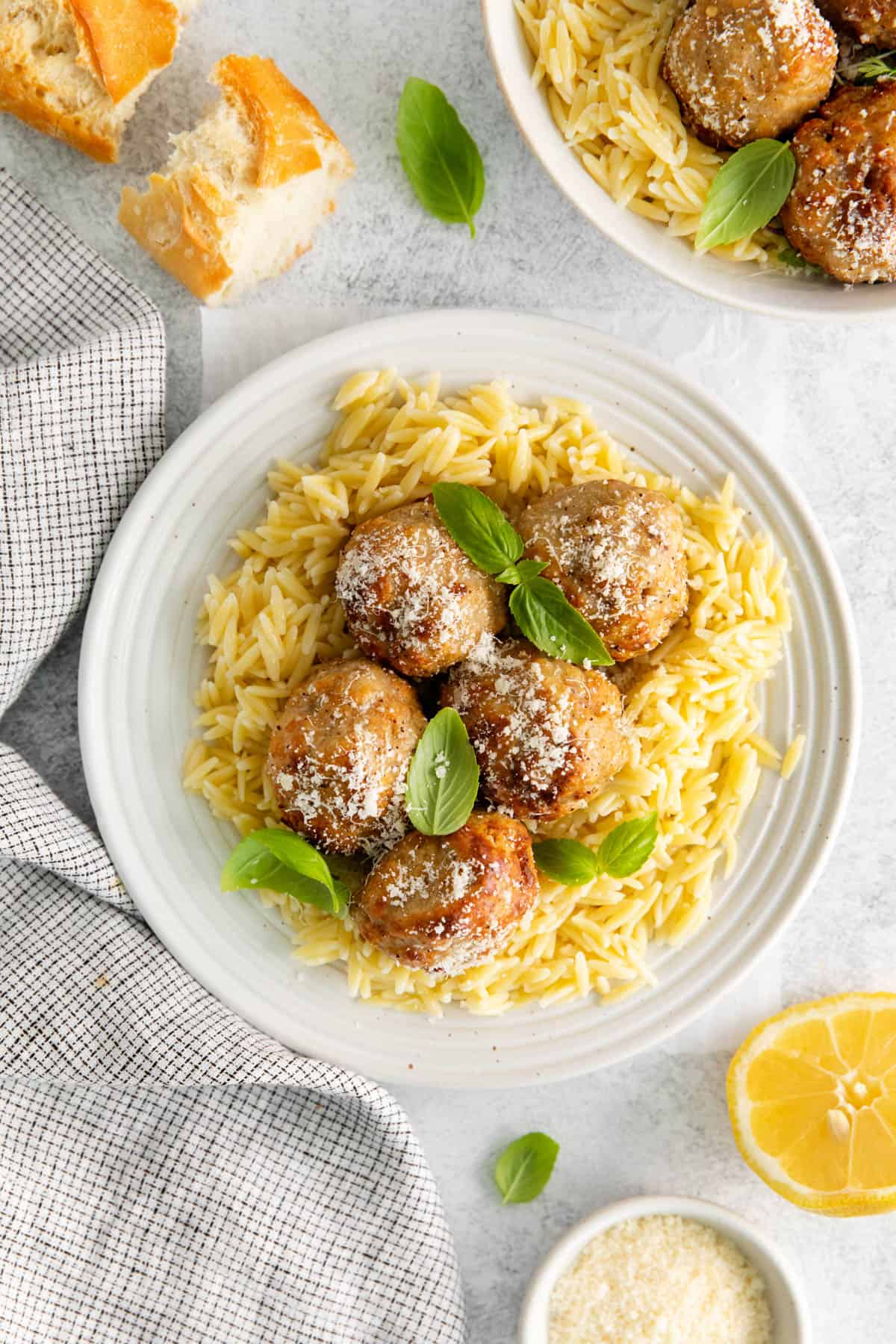 Five air fryer lemon chicken meatballs on a plate with pasta.
