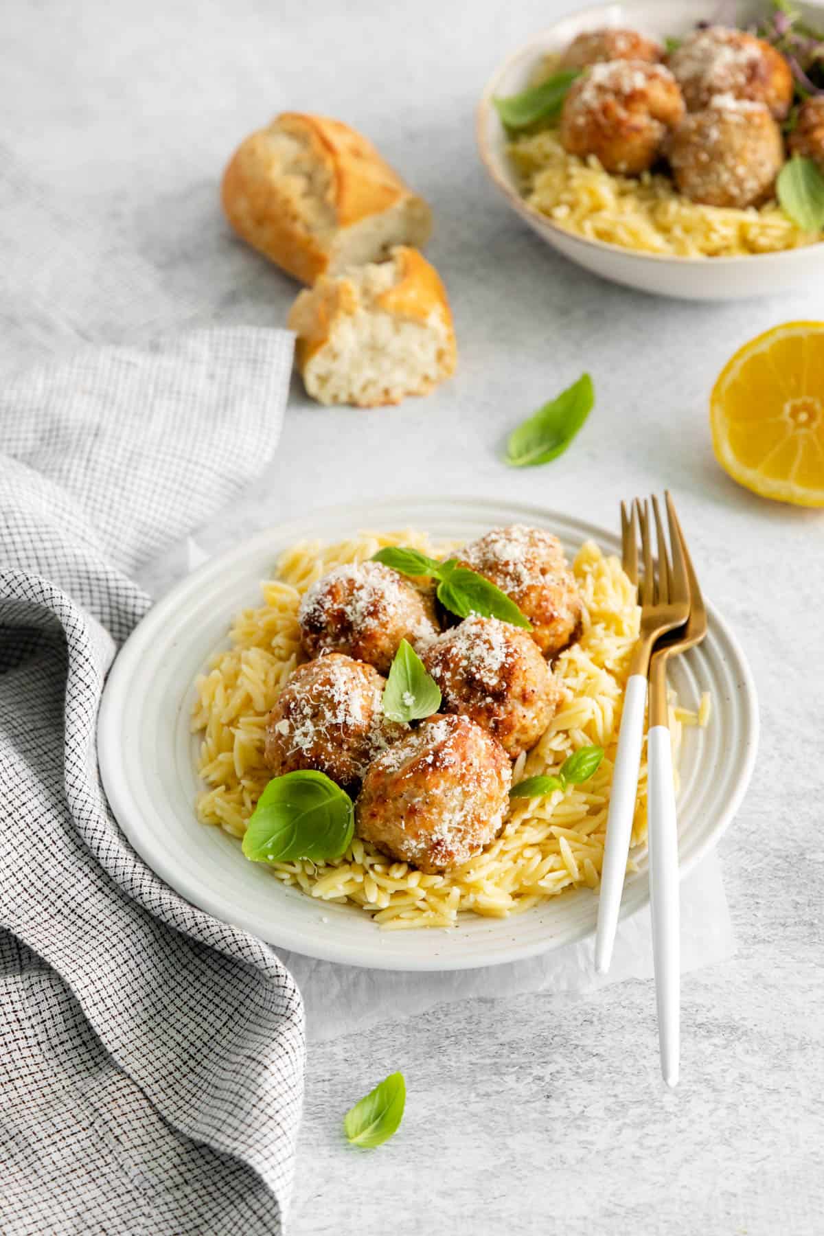 Air fryer lemon chicken meatballs on a bed of orzo pasta.