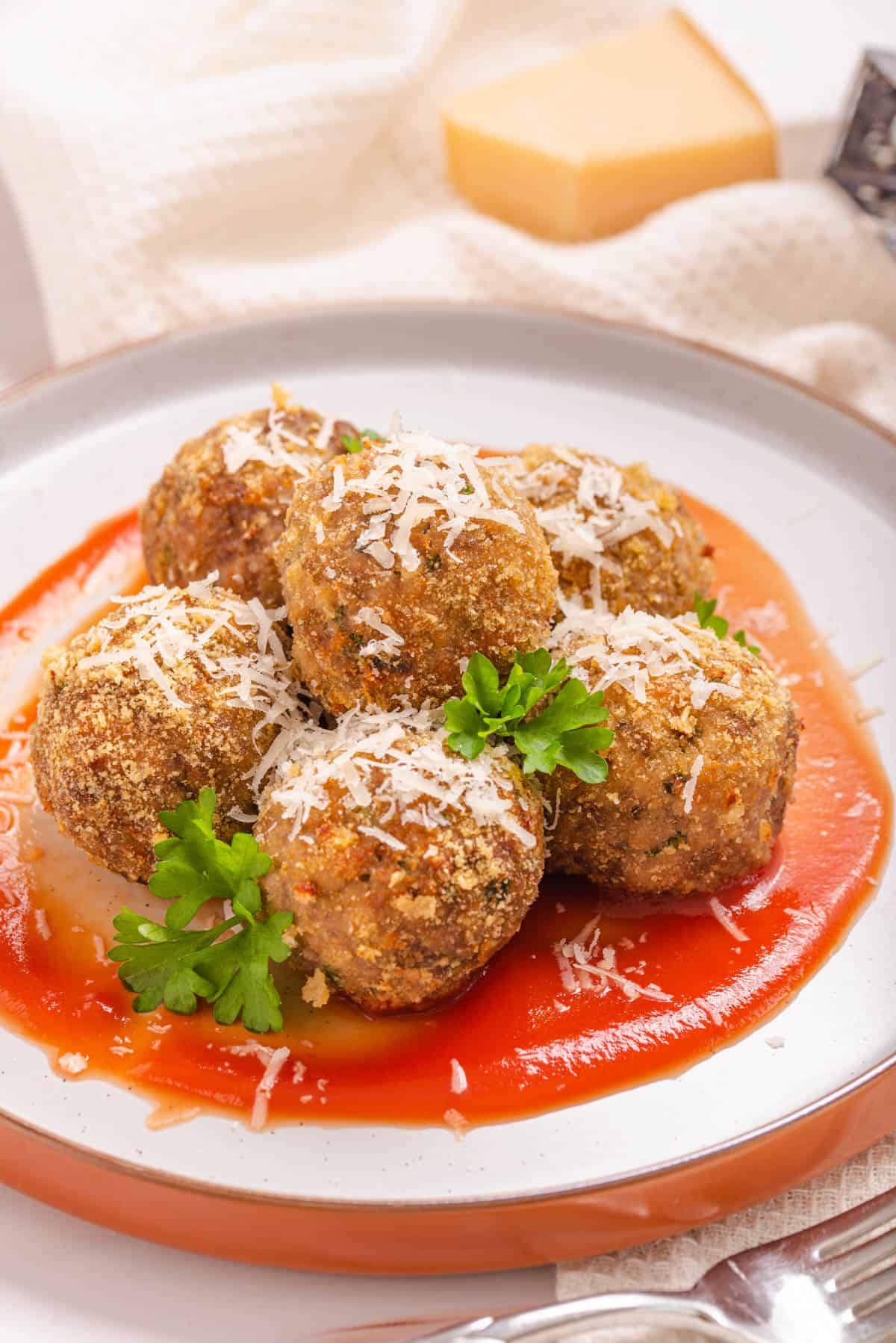 Air fryer meatballs on a plate with tomato sauce.