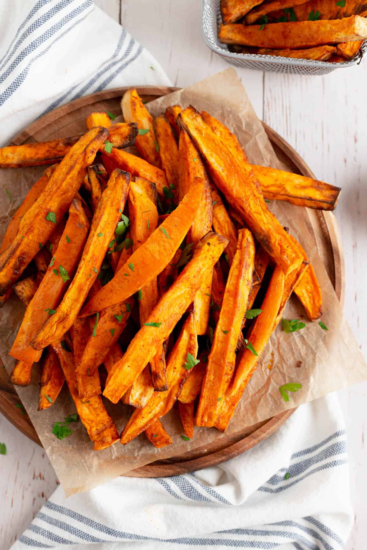 Overhead image of sweet potato fries sprinkled with chopped cilantro, in a serving bowl.  