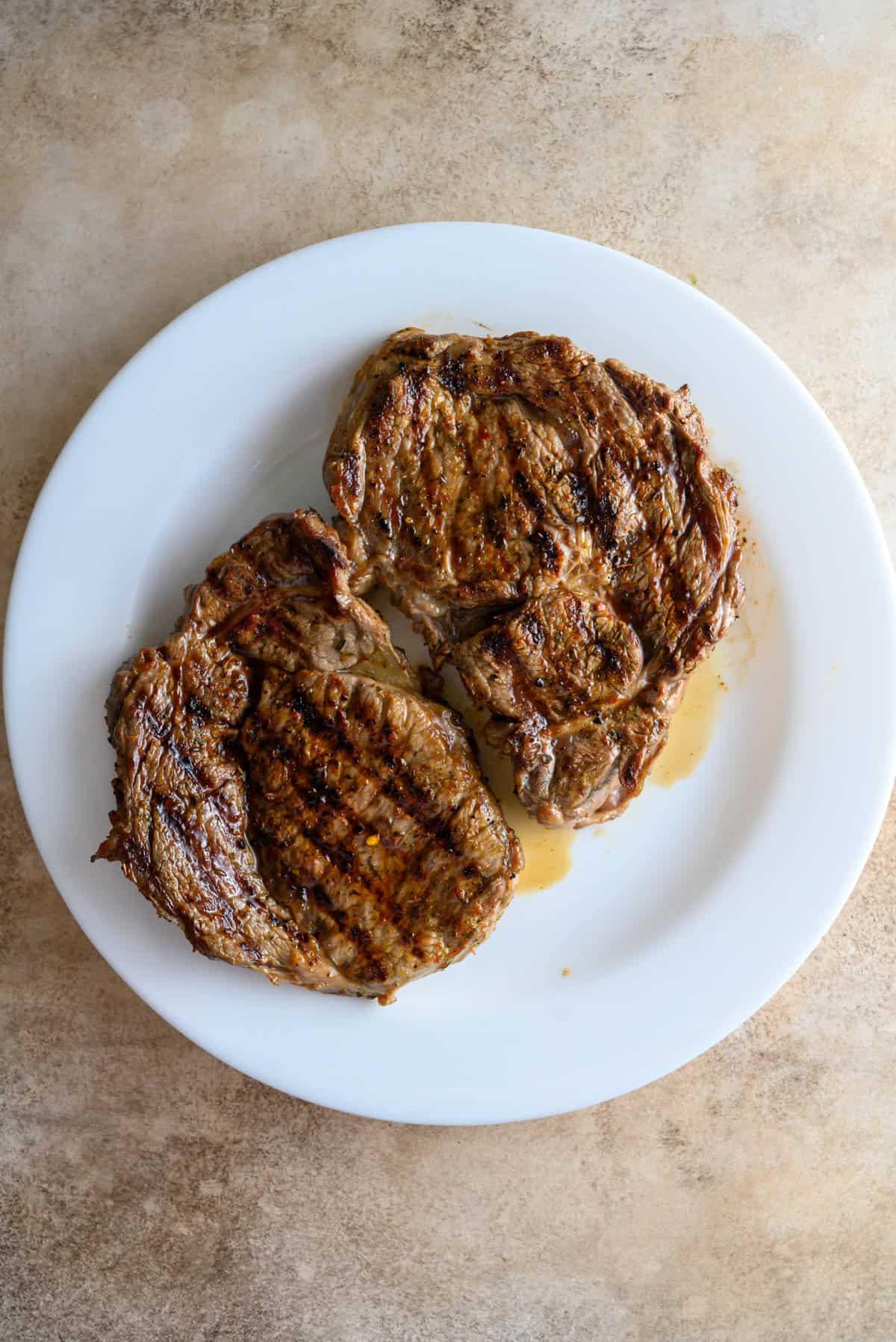 Grilled steaks resting on a plate.