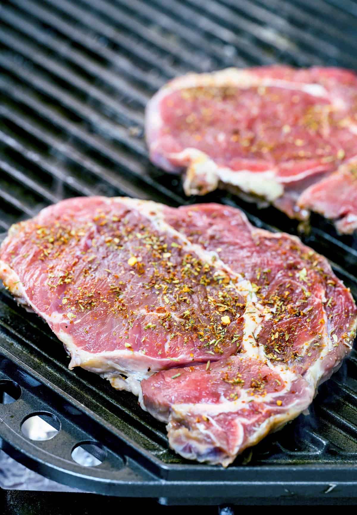 Cooking steaks on a hot grill.