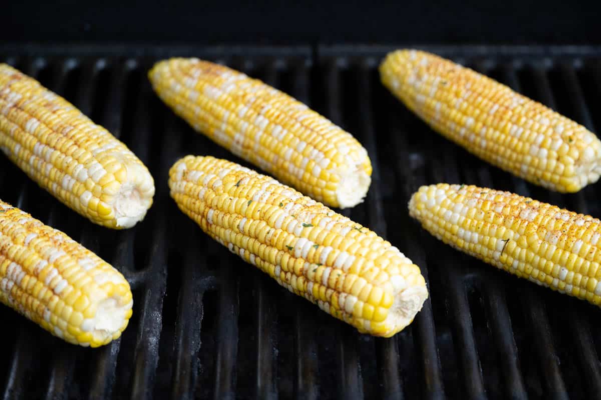 Six ears of corn on a grill.