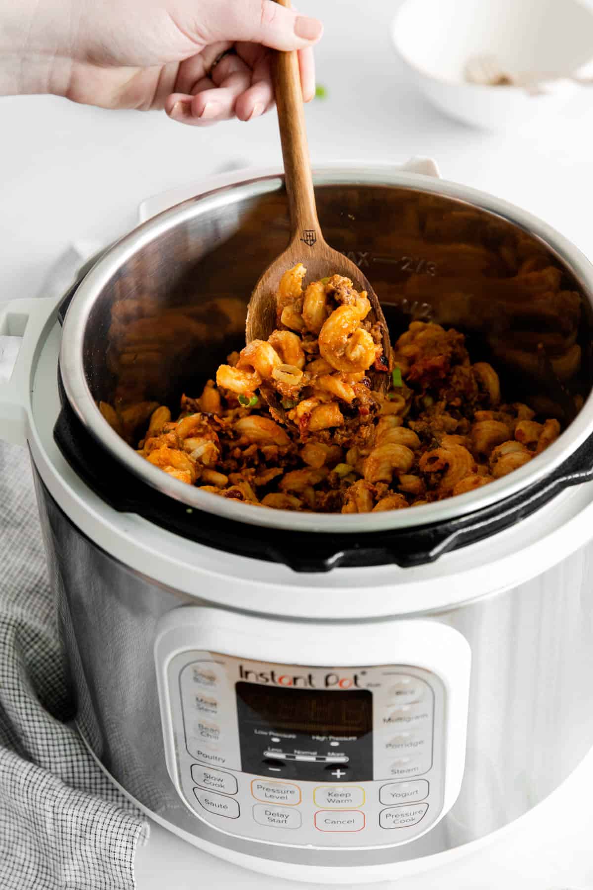 A spoon lifting chili mac out of the Instant Pot.