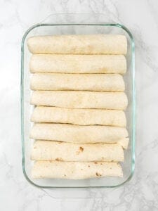 Rolled up enchiladas in glass dish