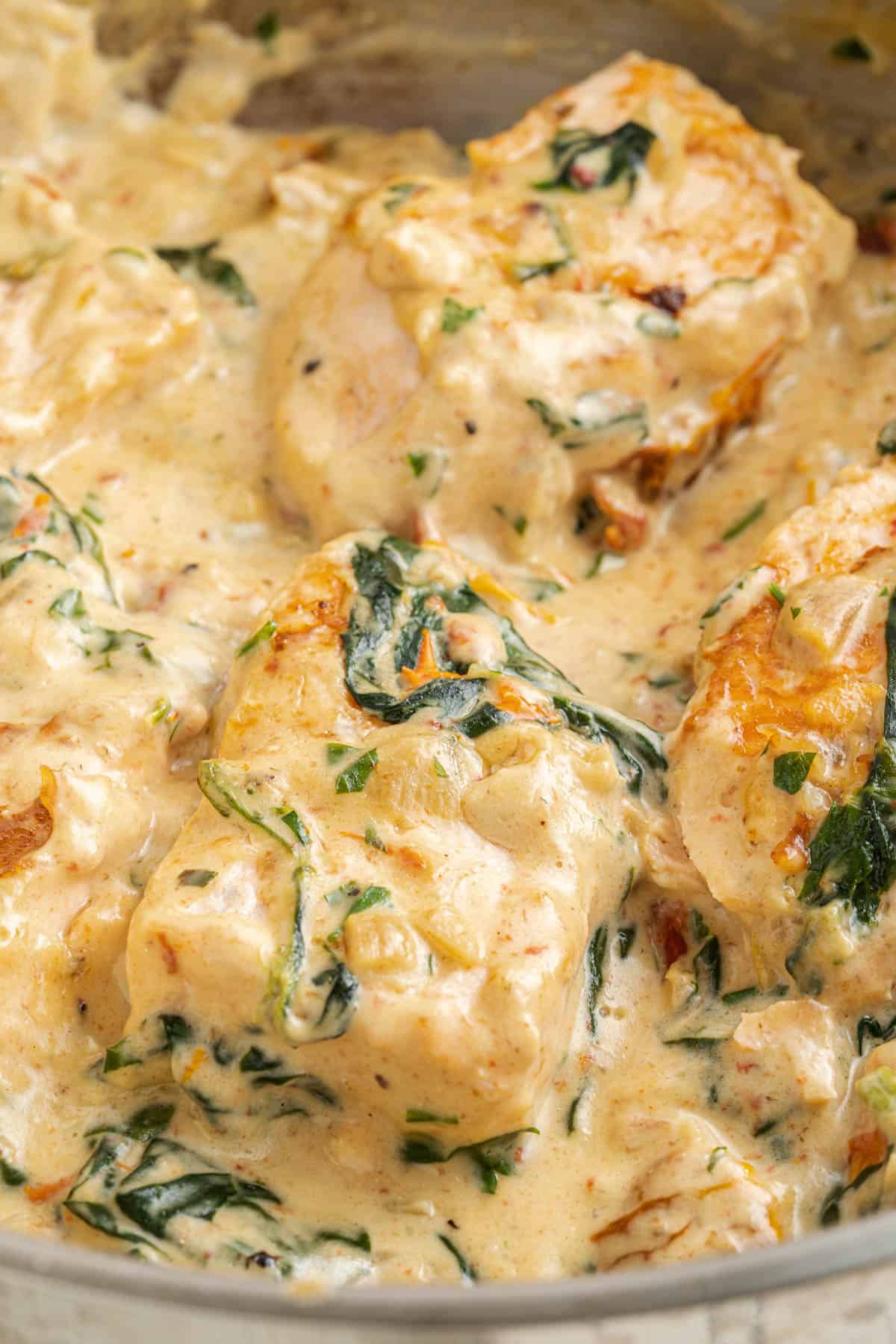 Creamy Tuscan salmon fillets in a pan.
