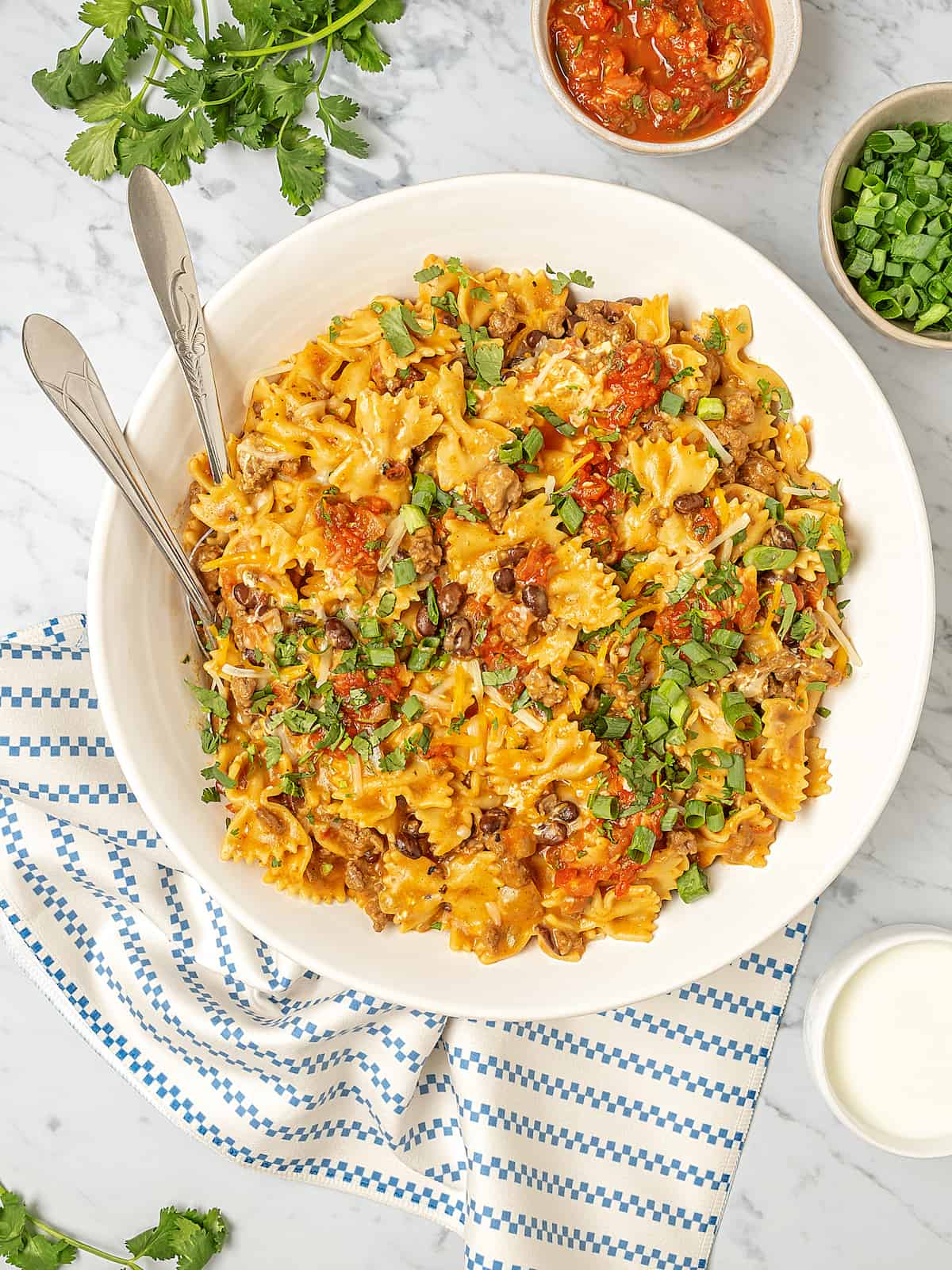 Serving bowl of Instant Pot taco pasta with garnishes