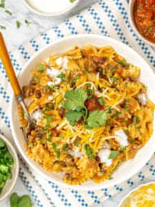 Overhead view of Instant Pot taco pasta with bowls of garnishes.