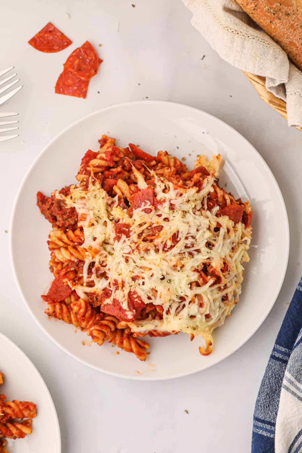 A serving of pizza pasta on a white plate.