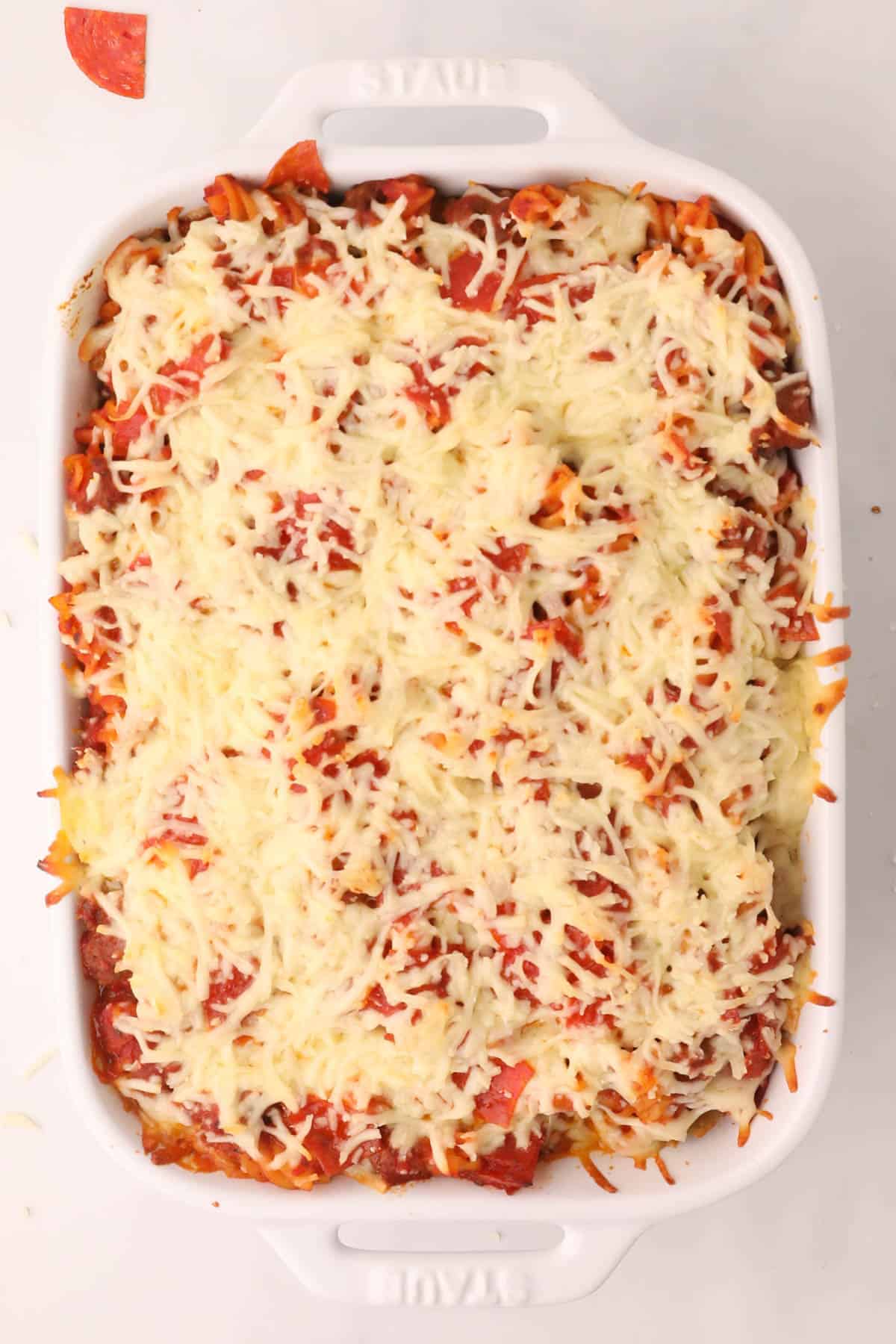 A baked pizza pasta casserole with melted cheese on top.