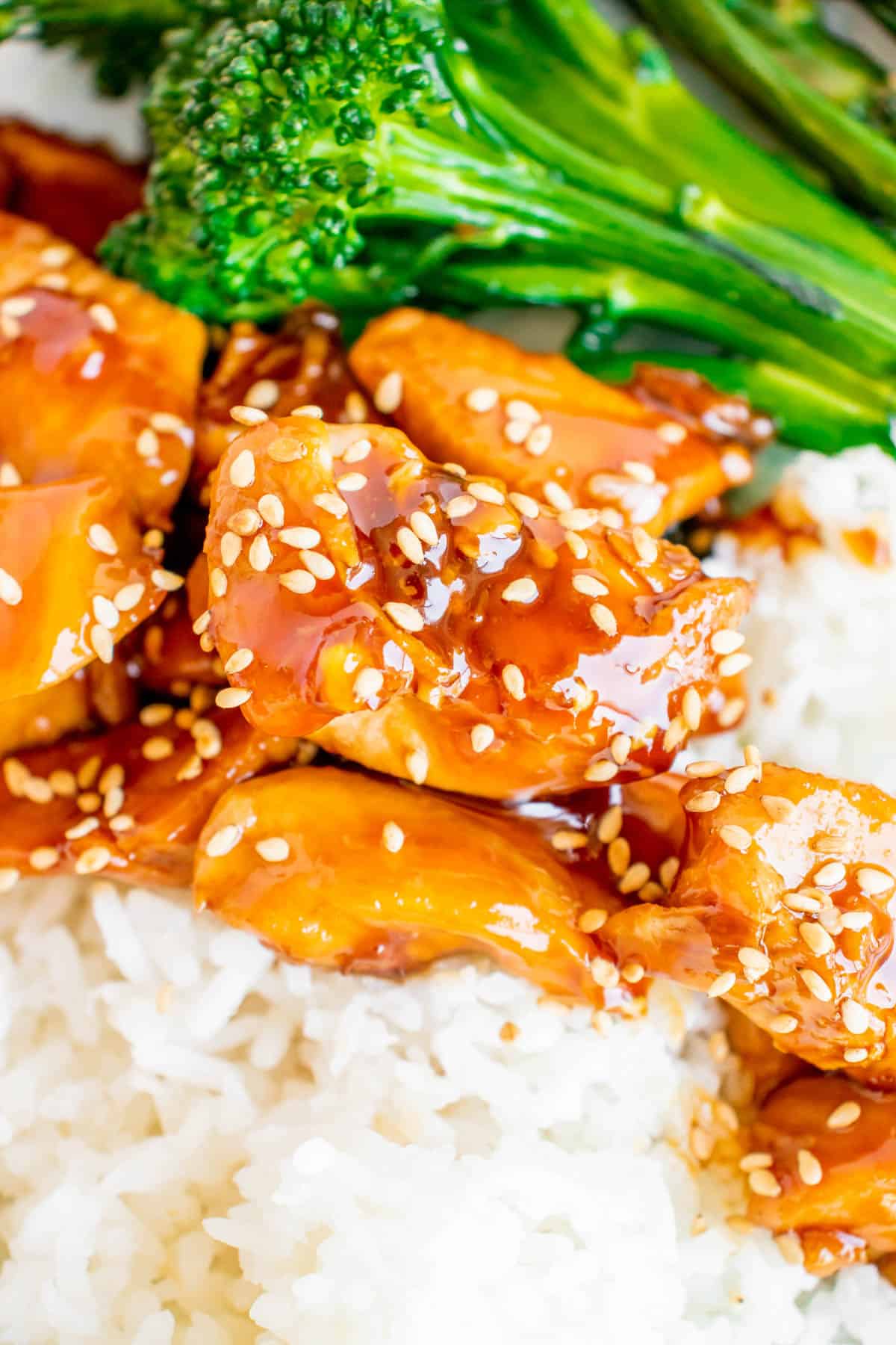 Close up image of Teriyaki chicken with Asparagus and Broccolini, served with sesame seeds and white rice. 