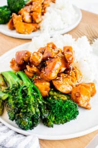 Honey garlic chicken on a plate with rice and broccolini