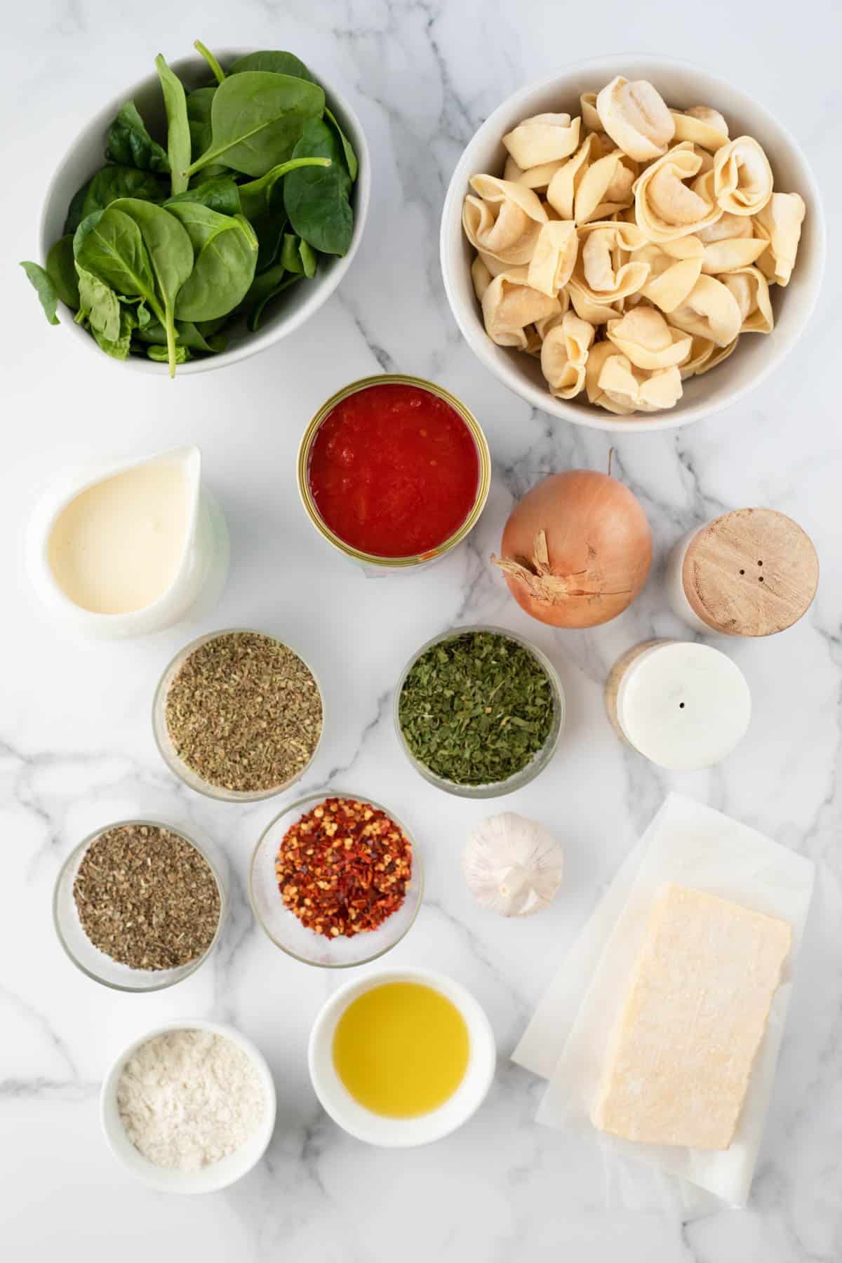 Ingredients for making creamy tomato and spinach tortellini.
