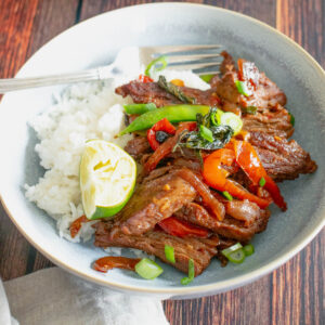 A bowl of beef stir fry with rice.