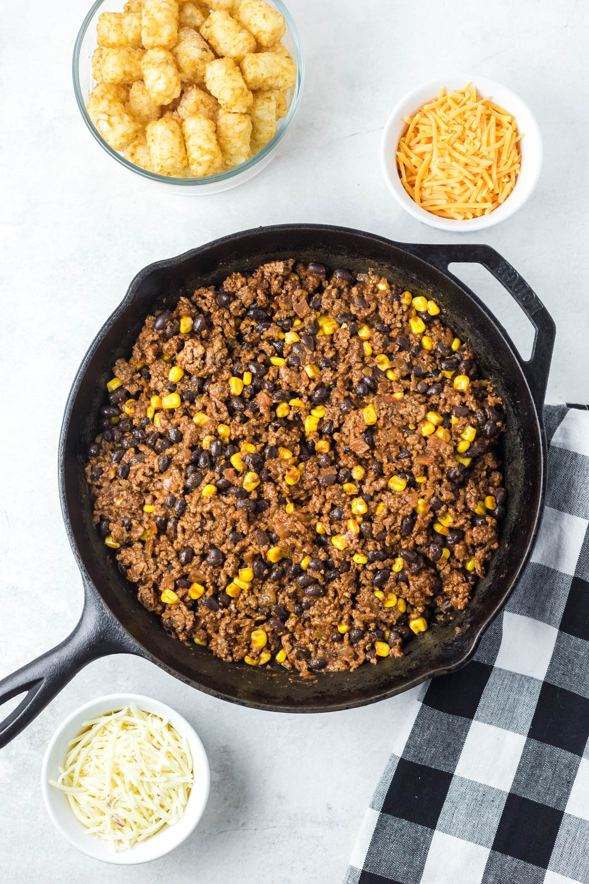 Browned ground beef, corn kernels, black beans and chunky salsa are blended together in a black cast-iron skillet. 