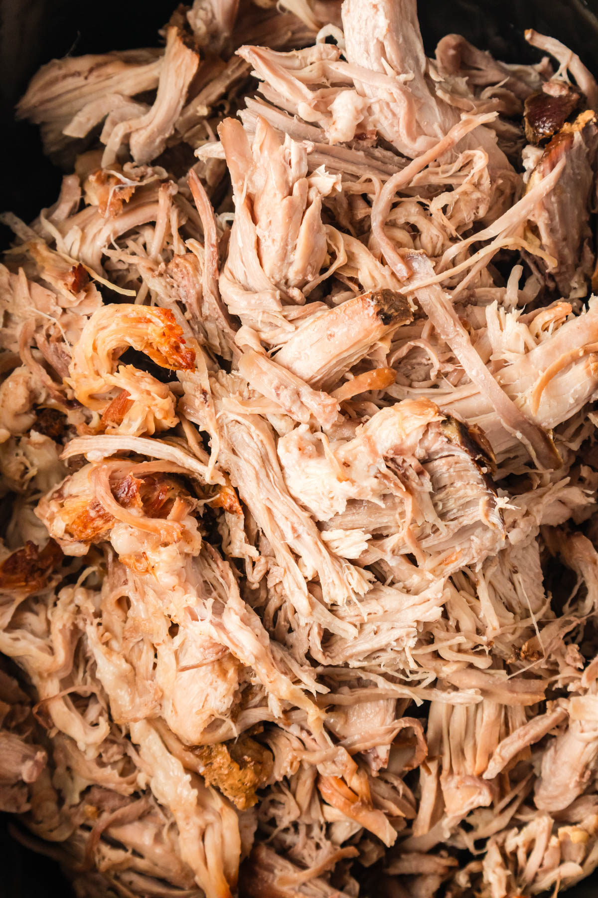 Close up image of shredded, cooked pulled pork. 