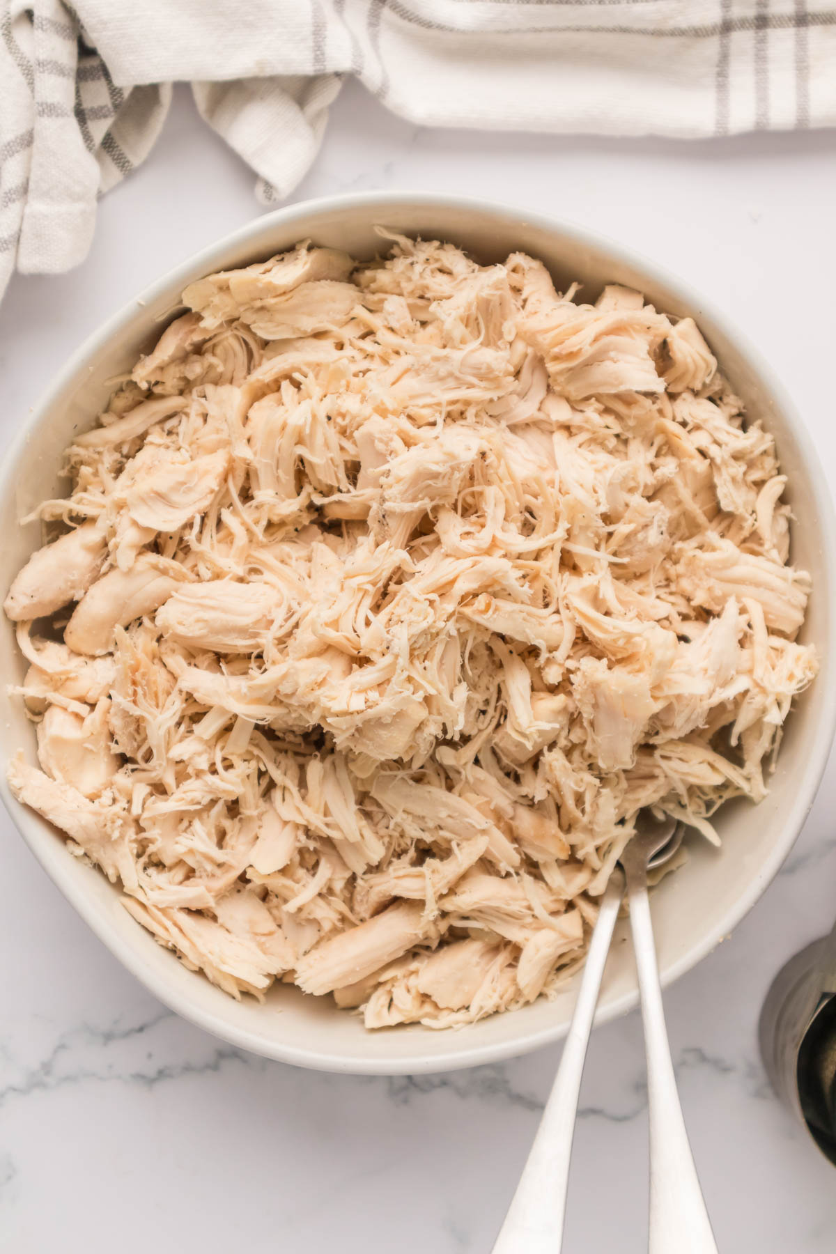 An overhead image of shredded chicken in a bowl.
