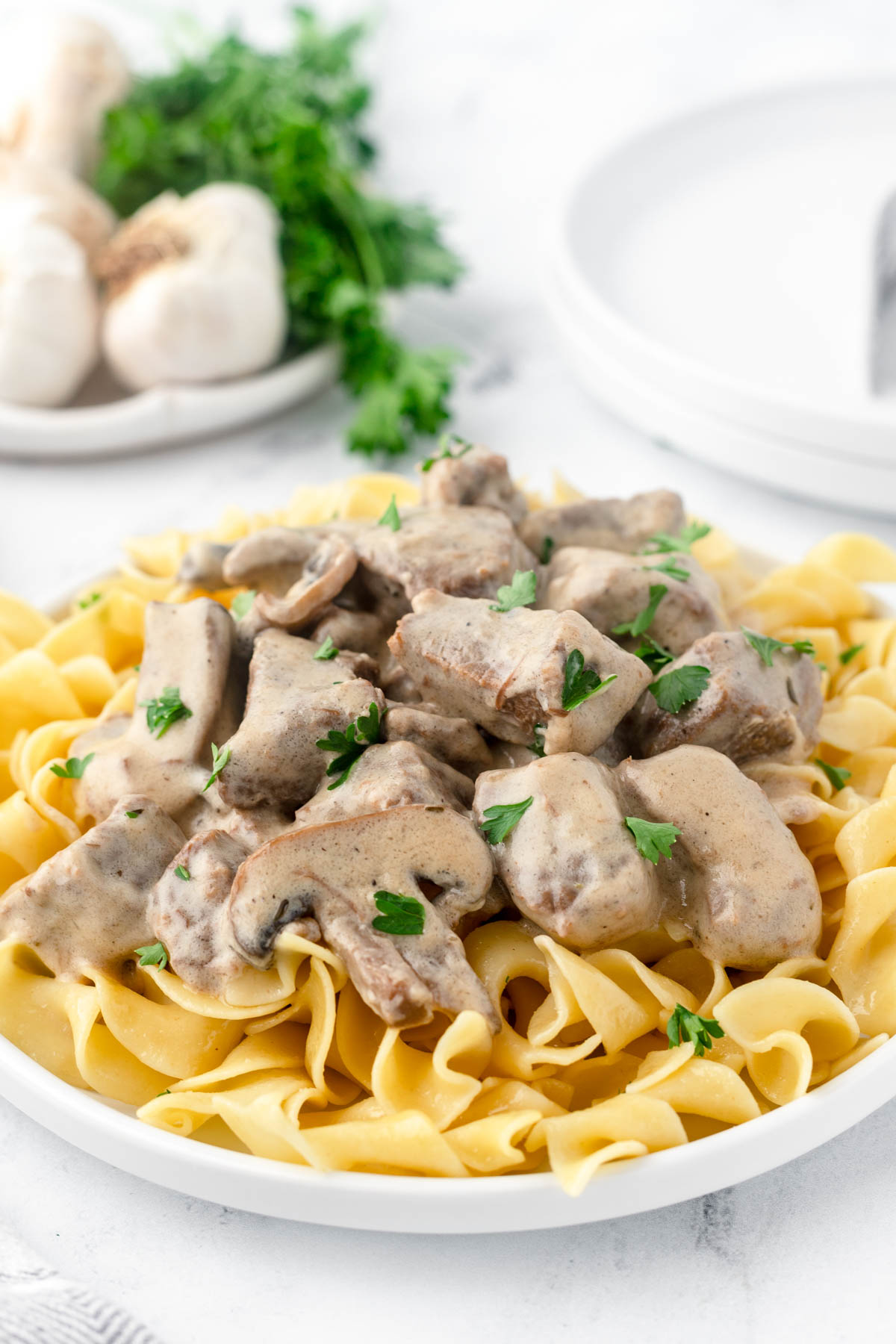 Close up image of beef stroganoff over a bed of noodles. 