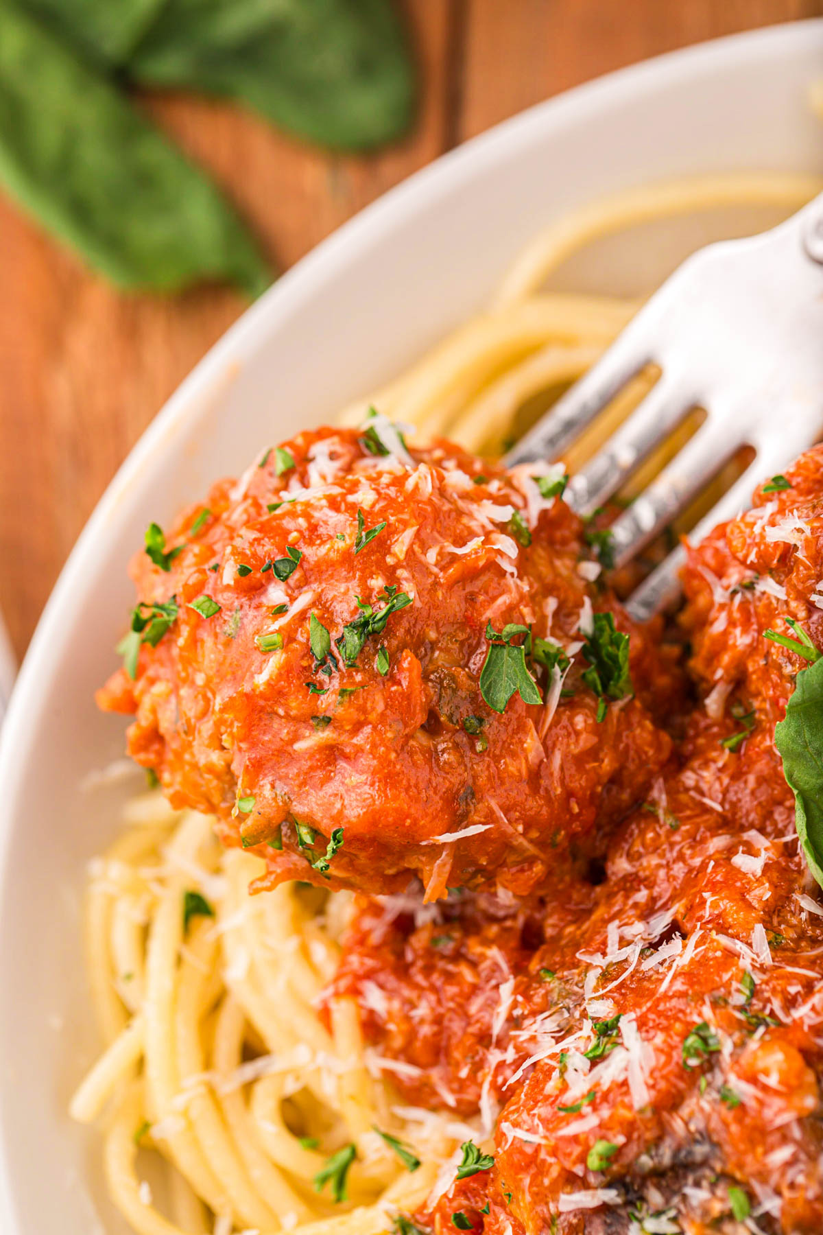 An image of a large meatball in marinara sauce.