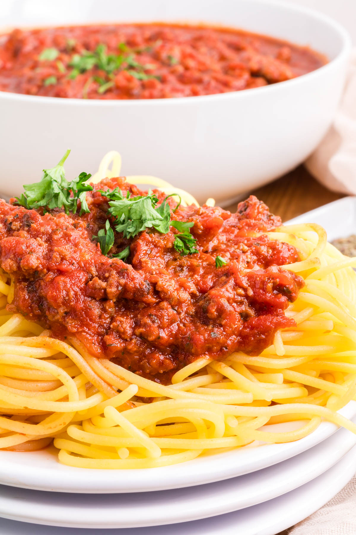Meat sauce piled on top of a plate of spaghetti noodles.