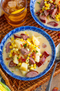 Kielbasa corn chowder is served in a blue soup bowl.